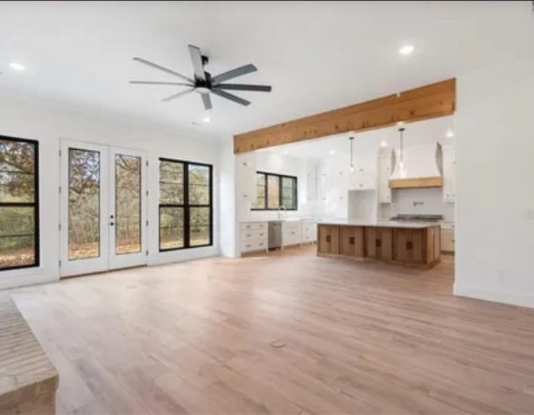 Spacious modern living area with large windows and wood accents.